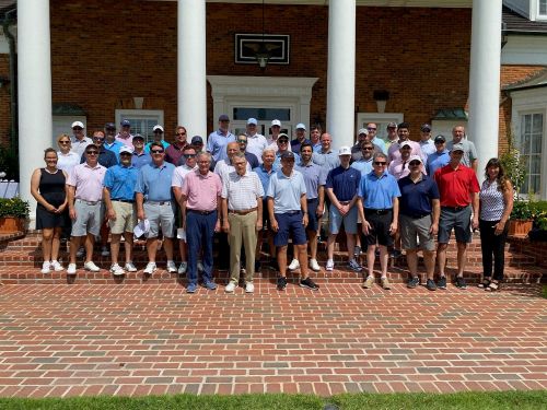 Large number of event golfers in front of clubhouse